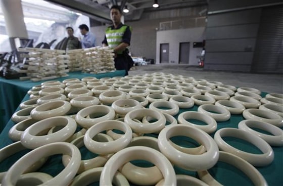 Customs officers stand guard near smuggled ivory bracelets at the Hong Kong Customs and Excise Department in Hong Kong Tuesday, Nov. 15, 2011. Hong Kong Customs seized a total of 33 unmanifested rhino horns, 758 ivory chopsticks and 127 ivory bracelets, worth about HK$17 million ($2.23 million), inside a container shipped to Hong Kong from Cape Town, South Africa. (AP Photo/Kin Cheung)